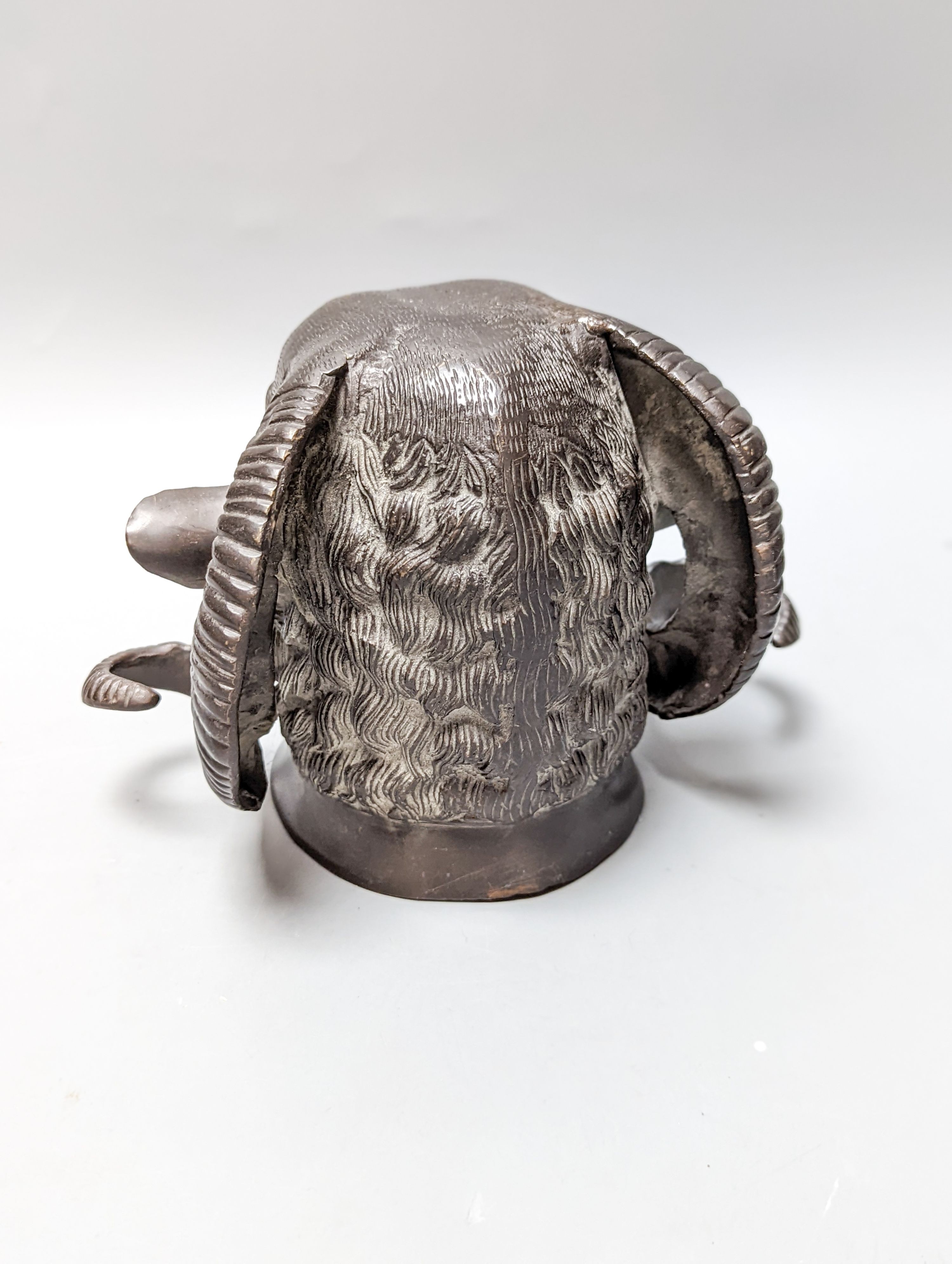 A bronze ram's head and a bronze relief
